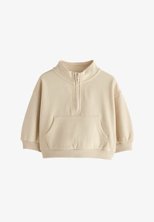 Beżowy sweter z długim rękawem, suwakiem do 1/4 długości, wysokim kołnierzem, kieszenią kangurzą, ściągaczami przy rękawach i u dołu, przedstawiony na białym tle.