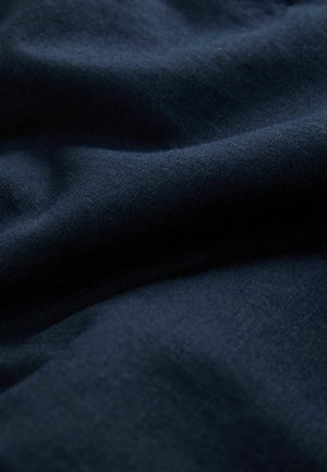 Tamnoplava tkanina s mekim naborima i suptilnom tkanom teksturom.