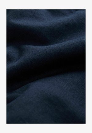 Tamnoplava tkanina s mekim naborima i suptilnom tkanom teksturom.