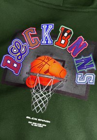 Groene sweatshirt met kleurrijke, gevarieerde typografie met de letters B, L, C, K, B, N, N, en een basketbalafbeelding in een ring.