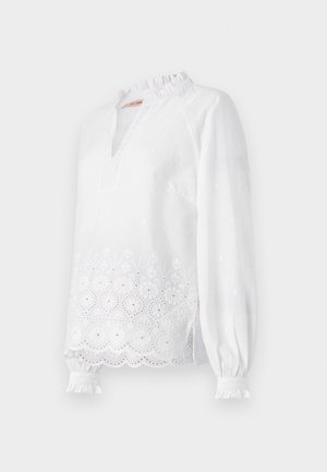 Valkoinen pitkähihainen pusero, jossa on frilla kauluksessa, brodeerattu kukkakuosi helman kohdalla ja hienovaraisia teksturoituja pisteitä koko pinnalla.