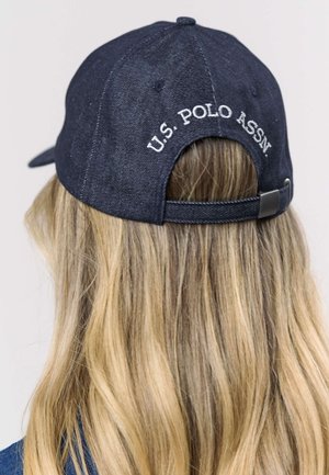 Dark denim baseball cap with an adjustable strap, featuring white embroidered "U.S. POLO ASSN." on the back. Smooth texture and structured shape.