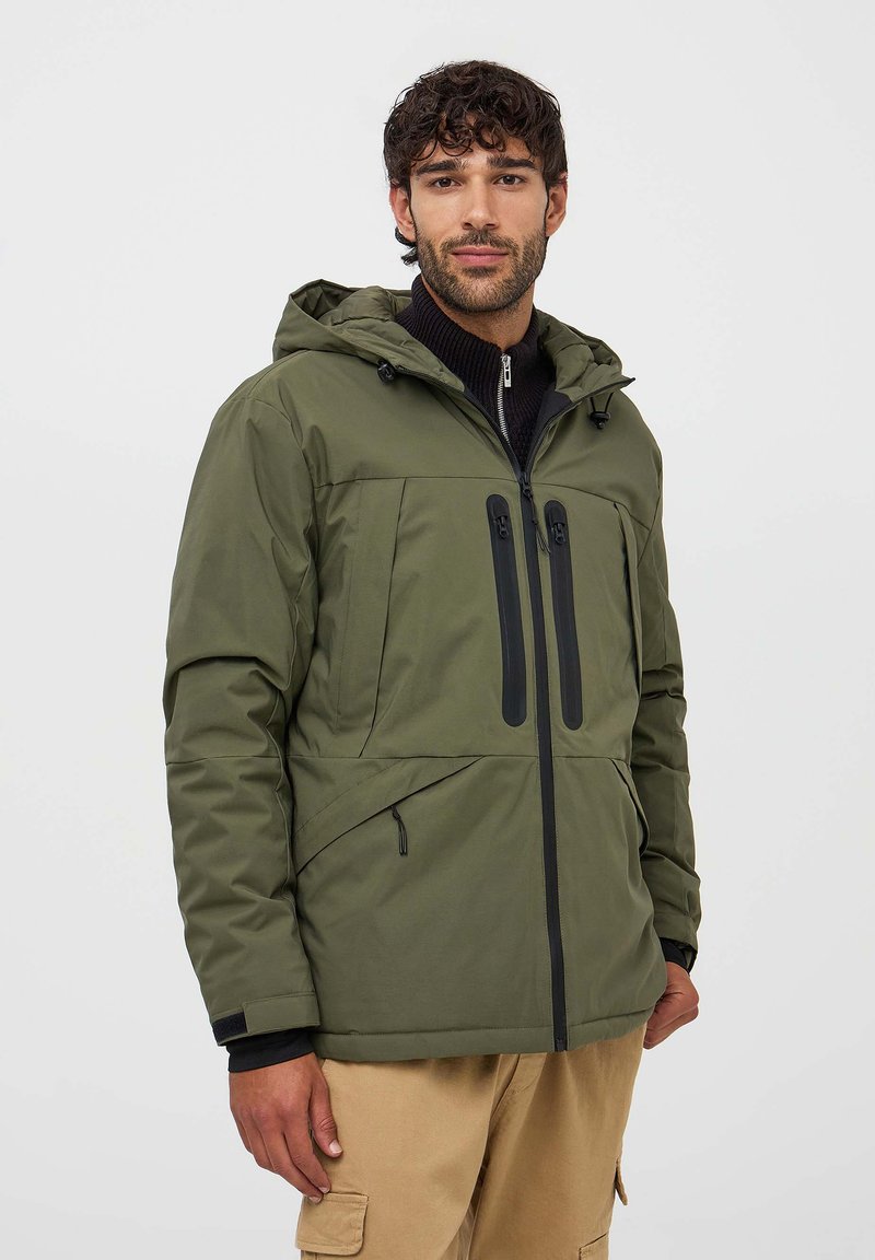 Giacca verde imbottita con cappuccio, dotata di zip e tasche nere, chiusura frontale con zip e un finish in tessuto strutturato.