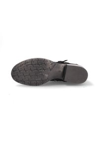 Semelle de chaussure noire en caoutchouc texturé, présentant un motif de crampons prononcé et des accents en cuir lisse. Design plat avec un profil bas.