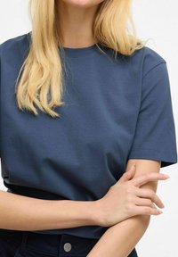 Camiseta de algodón de color azul marino con mangas cortas, escote redondo y textura suave. Diseño simple sin patrones o acentos visibles.