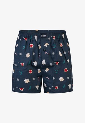 Marineblauwe boxershorts gemaakt van stof met een feestelijk patroon van peperkoekhuisjes, candycanes en winterse motieven.
