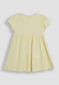 Robe jaune à manches courtes avec des rayures blanches, décolleté rond, jupe évasée et tissu en coton doux. La vue de dos montre les détails des coutures et le volume.