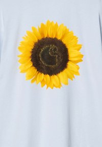 Camiseta de color azul claro con un gráfico grande y vibrante de un girasol con pétalos amarillos y un centro marrón oscuro, impresa en tejido suave.
