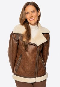 Braune Kunstlederjacke mit krèmfarbigem Schafsfellkragen, Reißverschl�üssen an der Taille und einer strukturierten Oberfläche. Verfügt über einen breiten Reverskragen und Schulterakzente.