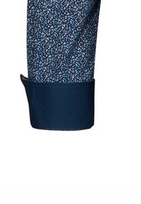 Polsino di camicia blu navy con un tessuto testurizzato e a motivi che presenta piccoli dettagli blu e bianchi. Finitura in tessuto liscia con polsino piegato.