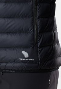 Gilet nero e voluminoso realizzato in tessuto resistente all'acqua, con cerniera laterale e logo "Premium Down". Texture liscia con pannelli cuciti.