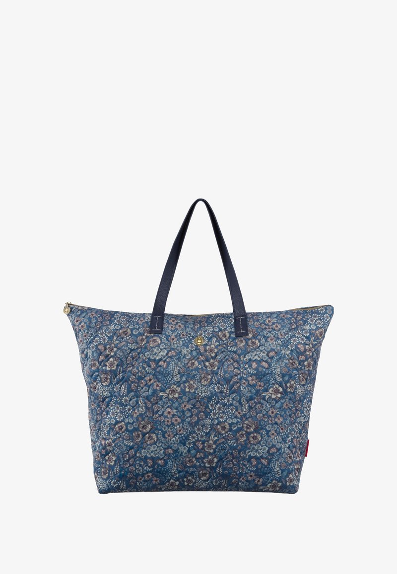 Blauw bloemenprint tote bag van stof, met twee marineblauwe handvatten, gouden hardware en een ritssluiting. De patronen bevatten verschillende bloemen.