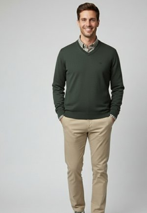 Suéter de pico verde oscuro sobre una camisa de cuadros con botones, combinado con chinos de color caqui claro. Textura suave y diseño ajustado.