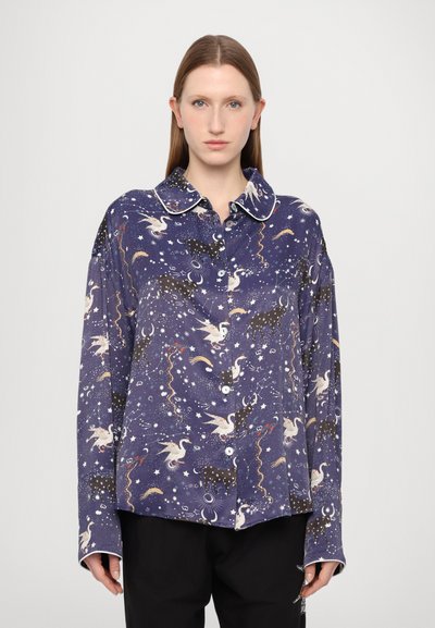 Chemise bleu marine à boutons avec un imprimé céleste et animalier fantaisiste, en tissu doux, à manches longues et avec un col contrastant blanc.
