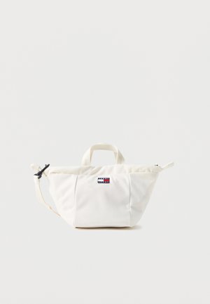 Ecru torba na ramię Tommy Jeans z krótkimi uchwytami, regulowanym paskiem na ramię i naszywką z logo z przodu na jednolitym tle.