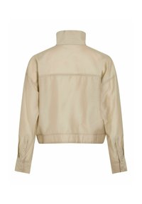 Veste beige à manches longues avec col haut, poignets boutonnés et détail de couture horizontale à l'arrière, vue de dos.