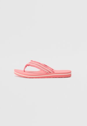 Chinelo cor-de-rosa com uma sola de borracha espessa e texturizada, e duas tiras de tecido com bordas desfiadas e riscas brancas de destaque.