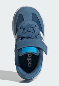 Námornícky modré športové topánky s textilným a semišovým vrchom, biele akcenty, šnúrkový uzáver a suchý zips. Majú polstrovaný, textúrovaný interiér.