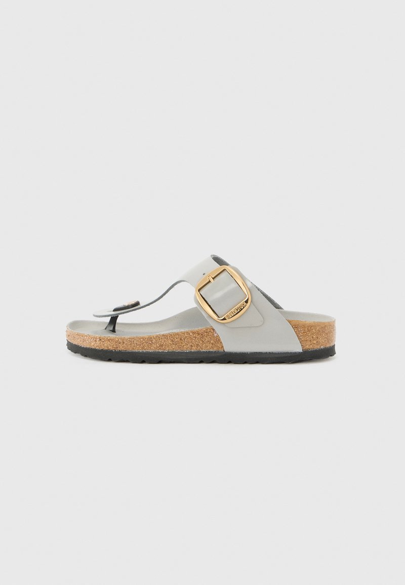 Grey flip-flop sandal with a cork base, featuring a wide strap and a gold buckle accent. Flexible sole, minimalistic design with a textured finish.