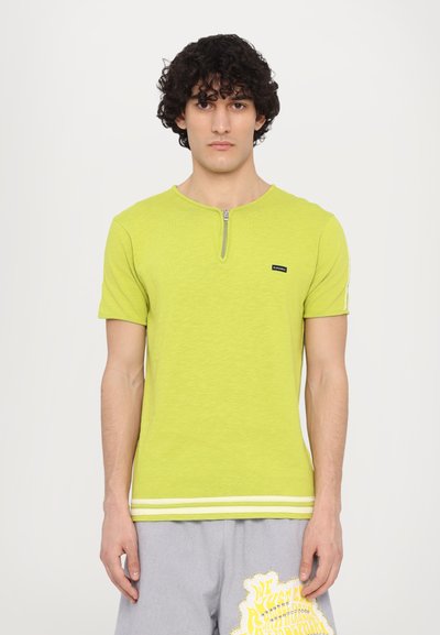 Korte mouwen, limoengroene t-shirt met een ritsenkraag en een klein merkembleem. Heeft een gestructureerde stof en contrasterende witte strepen aan de zoom.