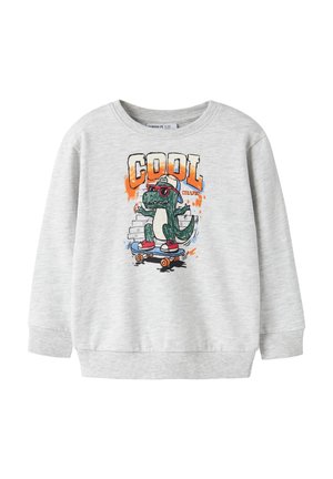Svetlosivá mikina s kresleným dinosaurom, ktorý nosí slnečné okuliare a čiapku, jazdí na skateboarde a nad ním je slovo "COOL" oranžovými písmenami.