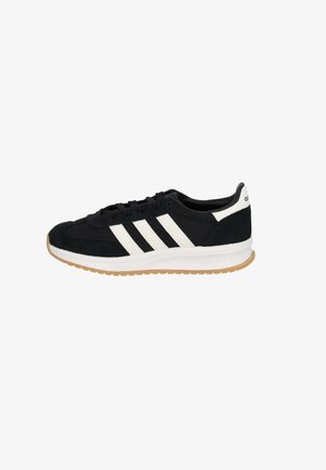 Zapatillas de ante negras con rayas blancas y una media suela blanca, que cuentan con una suela de goma y un diseño de punta redondeada.