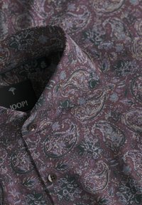 Herren-Hemd mit Knöpfen, in einem dunklen lila Grundton und aufwendigen Paisley- und Blumendesigns in Grau, Gelb und Schwarz.