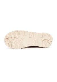 Suela de zapato de color beige claro con patrones texturizados, que incluyen surcos profundos y acentos elevados para mayor tracción. Material de goma, diseño robusto.