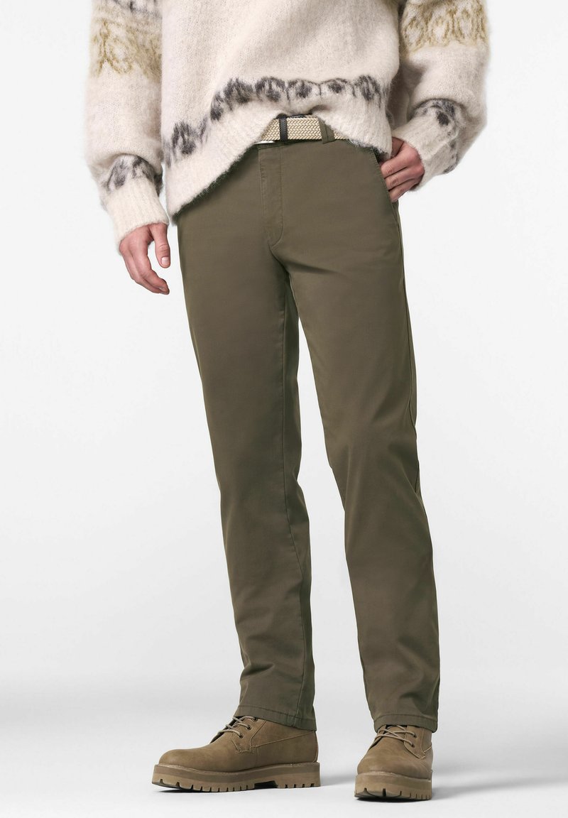 Olijfgroene chino's met een gladde textuur, voorzien van zijzakken, een getailleerd silhouet en gecombineerd met lichtbruine veterschoenen.