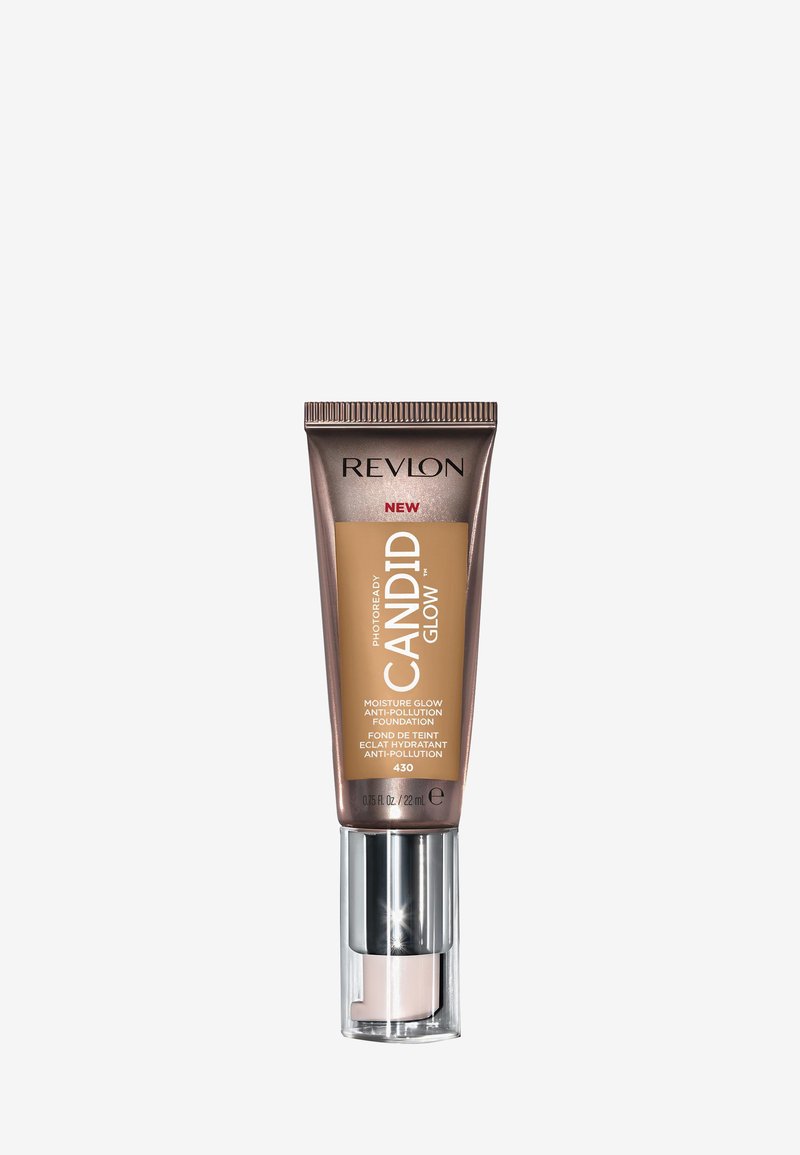Revlon Candid Glow foundation i en tube med brunt och gulddesign, med pumpdispenser och glänsande silverdetaljer. Storlek: 22 mL. Nyans 430.