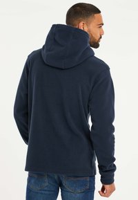 Navyblauwe fleece hoodie met een capuchon, lange mouwen en een gestructureerde stof. Het ontwerp heeft een rechte snit en een eenvoudige achterkant.