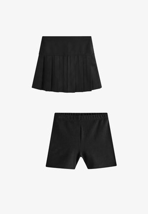 Mustmustritud laiemade äärtega must seelik elastse vööga ja sobivad mustad lühikesed püksid. Mõlemal tükil on sile tekstuur ja klassikaline disain.