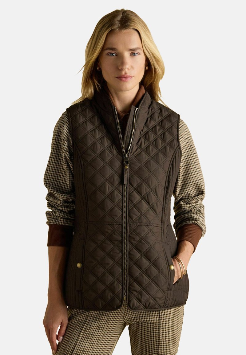 Brūns siltumizturīgs vests ar augstu apkakli, ar priekšējo rāvējslēdzēju un sānu kabatām. Audumam ir gluda tekstūra un smalka šūšana.