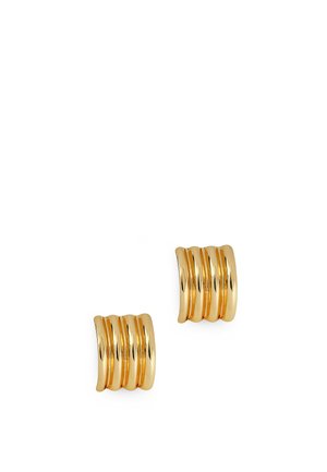 Paire de boucles d'oreilles clips dorées brillantes avec un large design incurvé comportant quatre rainures parallèles.