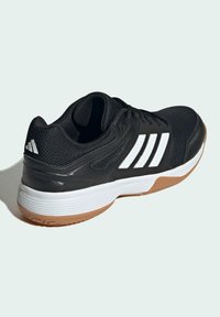 Black athletic shoe with a textured mesh upper. Features white three-stripe design, cushioned sole, and gum rubber outsole.