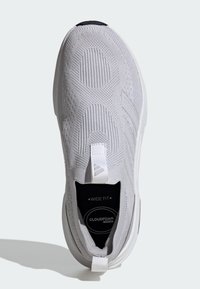 Vit träningsskor med övre del av stickad textil, strukturerad yta, bred passform-märke och Cloudfoam-dämpning. Har en dragflik vid hälen.