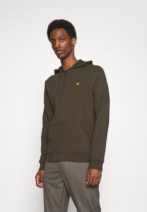 Sweat à zip couleur olive, fabriqué en mélange de coton doux, avec une poche avant et un petit logo jaune sur la poitrine. Texture lisse.