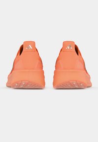 Πορτοκαλί αθλητικά παπούτσια με λείο υλικό και επάνω μέρος από δίχτυ, διαθέτουν επενδεδυμένο κολάρο και λαστιχένια σόλα με προσαρμοσμένα σχέδια πρόσφυσης.