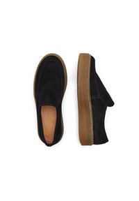 Juodi zomšiniai slip-on tipo batai su apvalia nosimi, guminėmis šviesiai rudos spalvos padais ir kontrastingomis siūlėmis. Minkšta tekstūra ir minimalistinis dizainas.