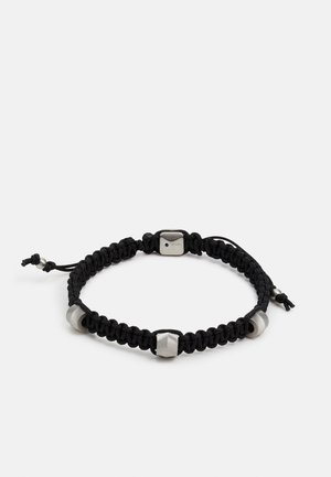 Bracciale intrecciato nero con perline esagonali metalliche e chiusura in acciaio, dotato di cordino regolabile per una vestibilità perfetta. Design testurizzato e minimalista.