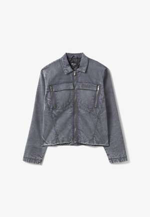 Giacca grigia con cerniera, due tasche sul petto con zip e pattine, tessuto strutturato e colletto, distesa su uno sfondo bianco.