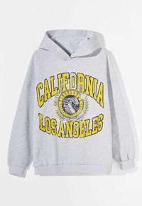 Šedá mikina s kapucí, která má velký žlutý potisk s nápisy "CALIFORNIA" a "LOS ANGELES", ozdobený grafikou a vavřínovými detaily. Měkká textura.