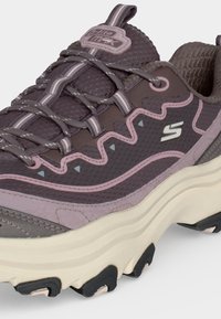Basket Skechers violette et rose avec une semelle blanche épaisse, tige en mesh à motifs et logos de la marque sur la languette et les côtés.