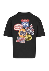 Black t-shirt featuring colorful graphic patches with text and designs, including "KANI," "Brooklyn Made," and retro numbers, on the back.