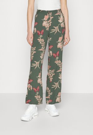 Pantalons à motif floral vert ornés de fleurs roses et de papillons rouges, fabriqués en tissu léger avec une coupe décontractée et évasée.