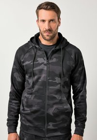 Zwarte camouflage zip-up hoodie met een voorkant rits, verstelbare trekkoordcapuchon en zijzakken. Gemaakt van gladde, rekbare stof.