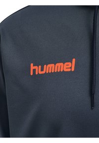 Sweat-shirt bleu marine avec une finition texturée, arborant un logo "hummel" orange bien visible sur la poitrine et une capuche à cordon de serrage.
