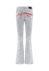 Lyseblå denim flared jeans med hvide broderede havmønstre ved kanten og rød "Ed Hardy" logo på den nederste del af bagbåndet.