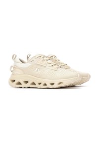 Zapatillas deportivas beige con una parte superior de malla transpirable, paneles texturizados, una suela acolchada con acentos recortados y cordones planos.