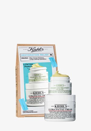 Kiehl's hudpleiesett med to hvite krukker, en med gul lokk. Esken merket "Fuktighetslindring" inneholder produktbeskrivelser og bruksanvisning.